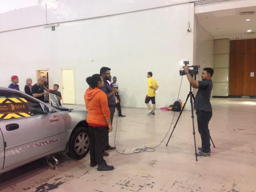 REKA archive photograph. Actual CRETA archive photograph of a camera crew and an interview beside the car. Source filename photo_2016-11-05_21-39-27.jpg supplies date context; outlet and exact event are not independently verified. A real press-context photograph, not a newspaper scan or a fabricated clipping.