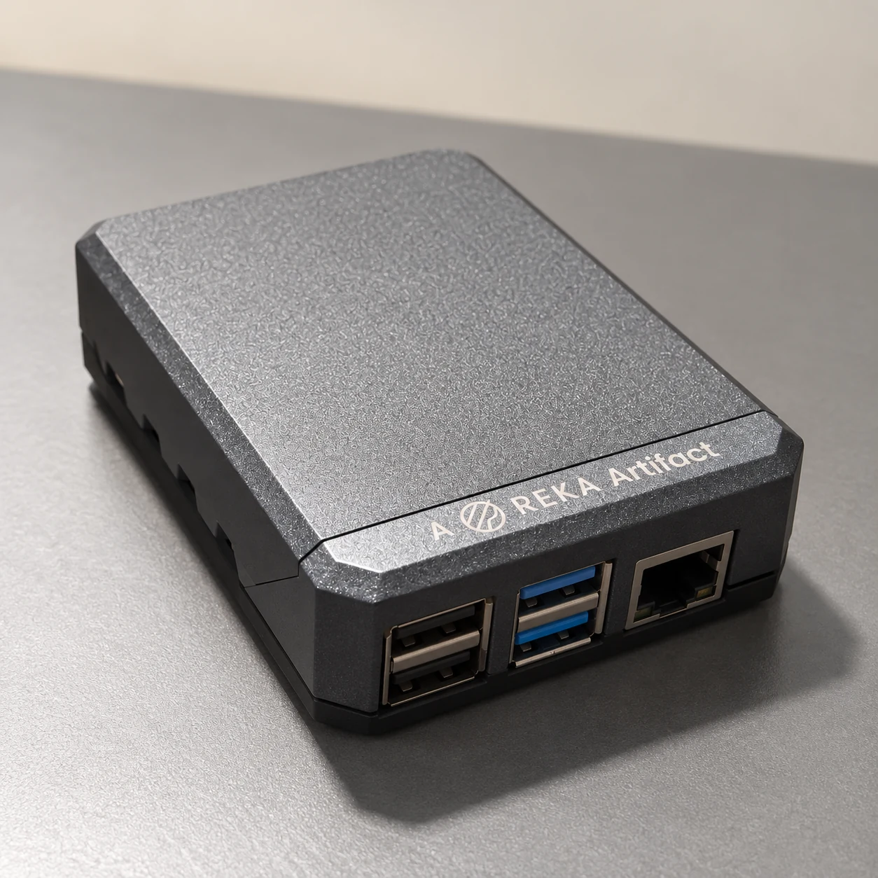 Reference-based AI-generated product photograph of the PLExyz Crowd Analytics unit shown in three user-supplied photographs: textured dark-grey chamfered enclosure, black base and existing USB/Ethernet-facing edge. Product illustration only, not a photograph of a MedAds installation or independently verified hardware specifications.